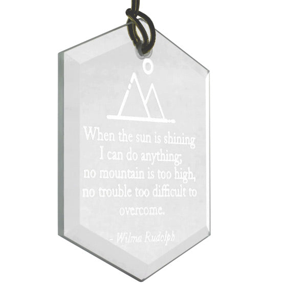 Custom Hexagon Glass Suncatcher With Gold String And Engraved With Mountain Artwork And Quote Against A White Background