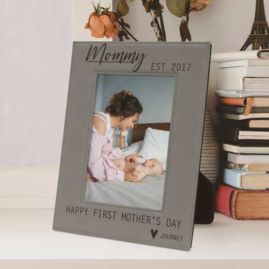 Custom Gray Faux Leather Picture Frame With Mother’s Day Text And Photo Of Mom And Newborn On Shelf With Stacks Of Books