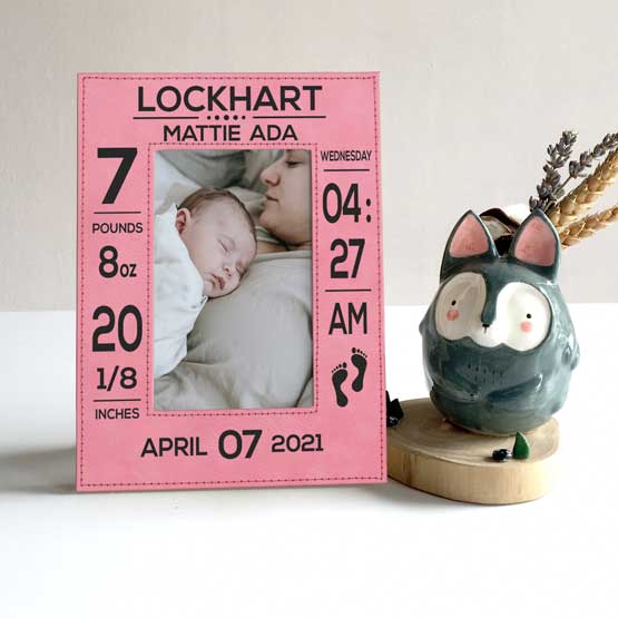 Custom Pink Faux Leather Picture Frame Engraved With Baby Birth Details And Photo Of Woman With Newborn On Shelf With Decor