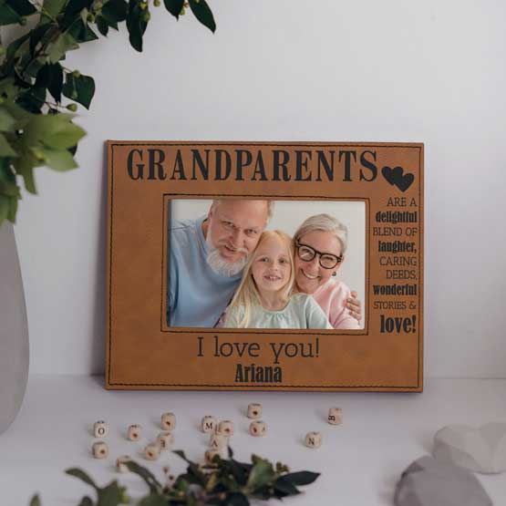 Custom Rawhide Faux Leather Picture Frame With Sweet Message And Photo Of Grandparents With Girl On A White Shelf With Plant