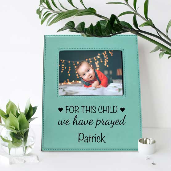 Custom Teal Faux Leather Picture Frame With Baby Photo And Engraved With We Have Prayed Message On Shelf With Plants