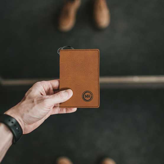 Man Hand In Front Of Mirror Holding Custom Rawhide Faux Leather Keychain Wallet ID Holder Laser Engraved With Initials