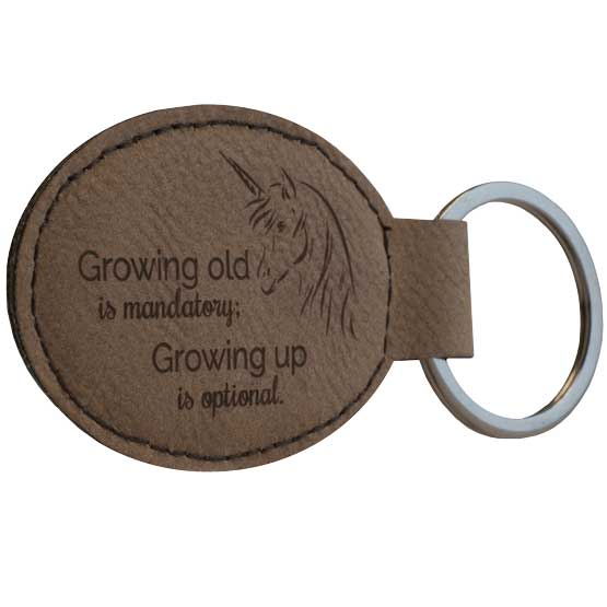 Dark Brown Faux Leather Oval Keychain Engraved With Unicorn Art And Growing Old Is Mandatory Growing Up Is Optional Text