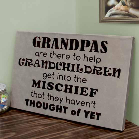 Gray Faux Leather Wrapped Rectangle Canvas Engraved With Grandpas Teaching Mischief Message On Shelf Near Picture Frame