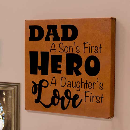 Rawhide Faux Leather Wrapped Square Canvas With Dad A Son’s First Hero And Daughter’s First Love Text On A Living Room Wall