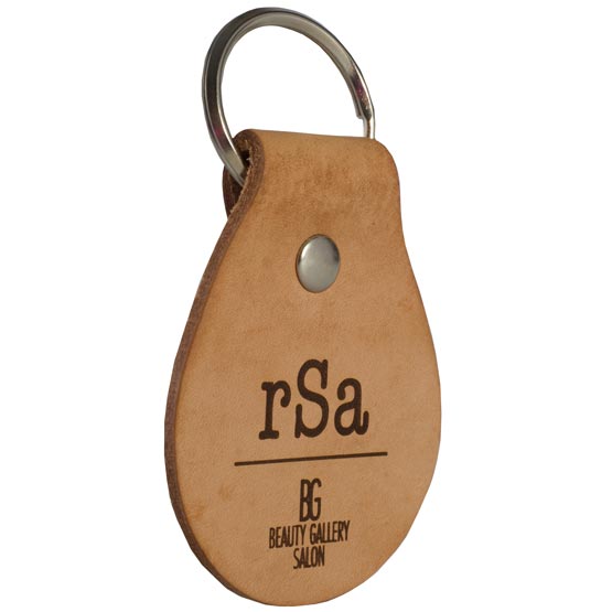 Light Brown Leather Teardrop Keychain Laser Engraved With Initials And Beauty Gallery Salon Logo Against White Background