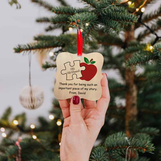Hand Hanging Ornate Maple Wood Ornament With Print Of Puzzle Piece And Apple And Teacher Thank You Message On Christmas Tree