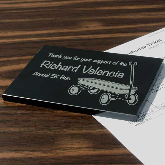 Black Marble Paperweight Engraved With Pull Wagon Art And Name And Thank You Message On Wood Office Desk With Work Document