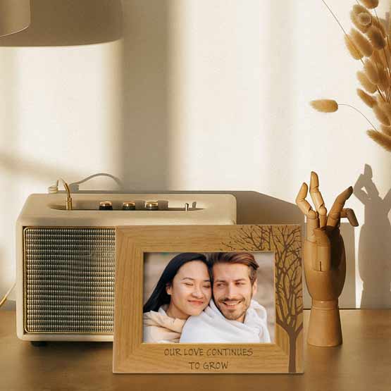 Red Alder Picture Frame With Couple Photo And Engraved With Tree Art And Our Love Continues To Grow Text On Shelf With Radio