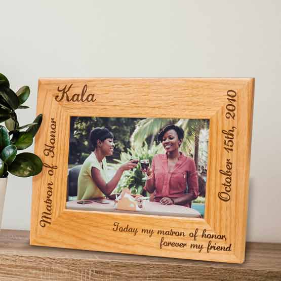 Red Alder Picture Frame With Photo Of Happy Women And Engraved With Name And Date And Maid Of Honor Message On Shelf By Plant