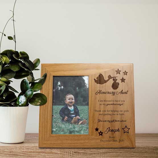 Red Alder Picture Frame With Baby Photo And Stork Art And Guardian Angel Aunt Message And Baptism Info On Shelf With Plant