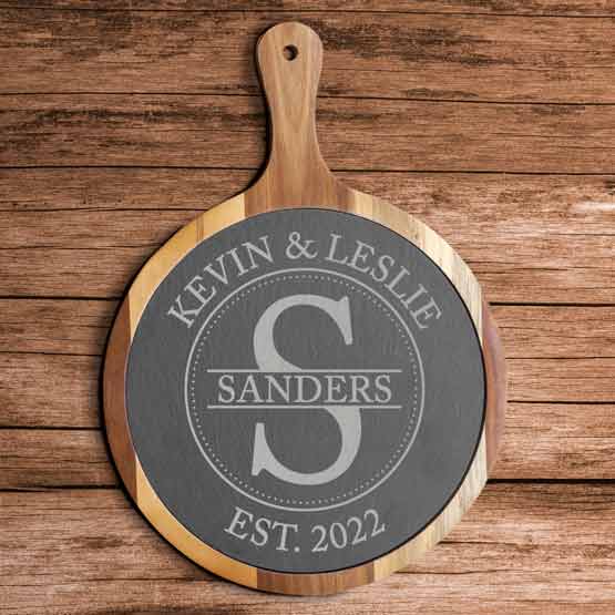 Round Cutting Board Style Sign In Acacia Wood Paddle And Printed With Couple Names And Monogram And Date On Wood Table