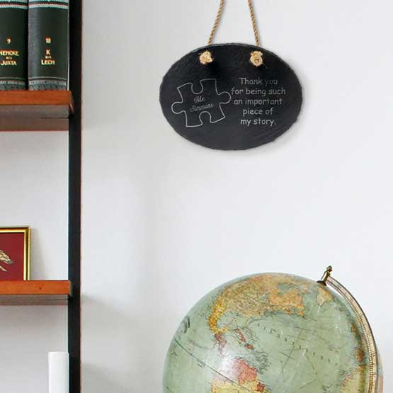 Slate Oval Sign Printed With Puzzle Piece Art And Teacher Thank You Message Hanging On Wall Via Rope By Shelves And Globe