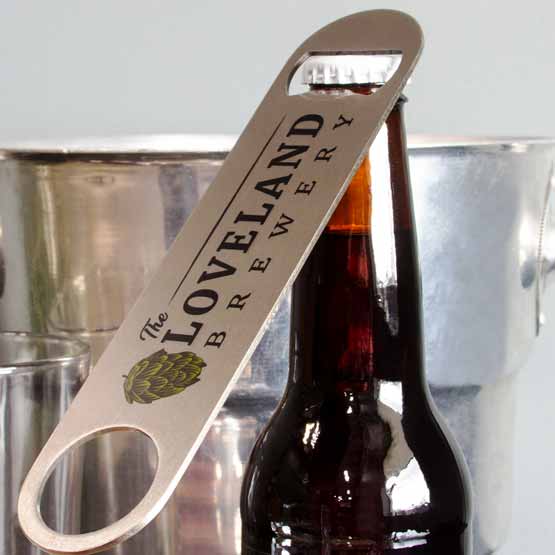 Custom Stainless Steel Bottle Opener With Full Color Logo Of The Loveland Brewery Leaning Against A Beer Bottle