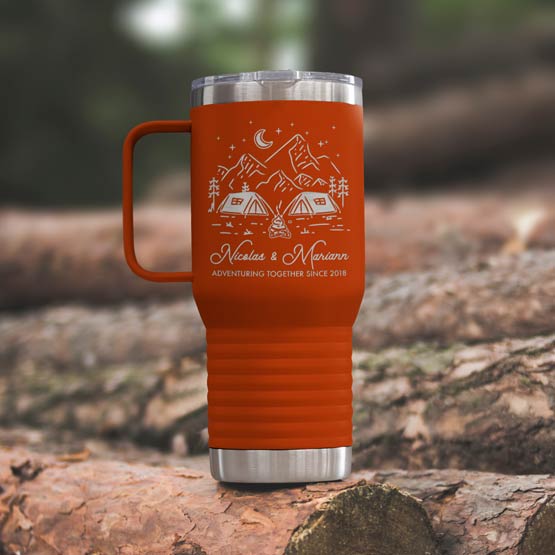 Orange Stainless Steel Coffee Tumbler With Handle And Engraving Of Camping Art And Names And Date On Wood Log Outdoors