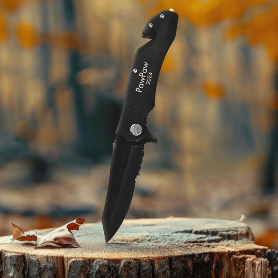 Custom Black Stainless Steel Rescue Knife In Open Position And Laser Engraved With PawPaw 2024 Piercing A Log Outdoors