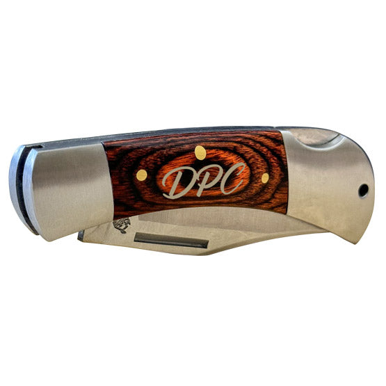 Custom Stainless Steel Folding Knife With Wood Style Handle And Laser Engraved With Initials Against A White Background