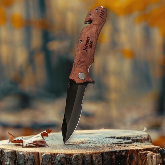 Custom Wood And Stainless Steel Rescue Knife Unfolded And Laser Engraved With Jensen 2024 And Piercing A Log Outdoors