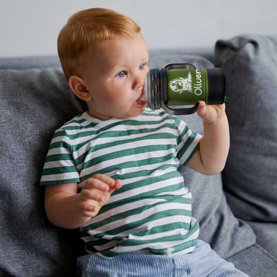 Child On Couch Drinking From Custom Olive Green Stainless Steel Sippy Cup With Handles And Engraved With Name And Clipart