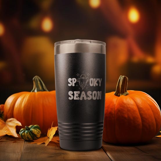 Custom Black Stainless Steel Coffee Tumbler Engraved With Ghost Art Inside Spooky Season Text On Table With Pumpkins