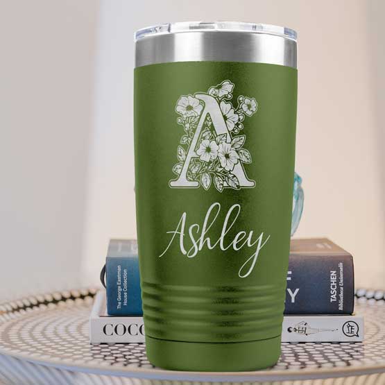 Olive Green Twenty Ounce Stainless Steel Coffee Tumbler Engraved With Ashley And Monogram And Flower Art On Table With Books