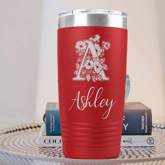 Red Twenty Ounce Stainless Steel Coffee Tumbler Engraved With Ashley And Monogram And Flower Art On Table With Books
