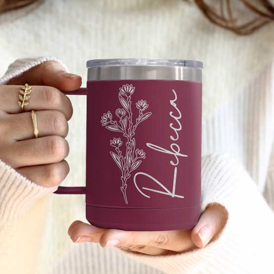 Woman Hands Holding Maroon Stainless Steel Coffee Tumbler Mug With Handle And Engraved With Name And Flower Art