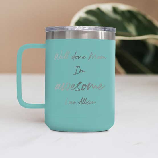 Teal Stainless Steel 15 Ounce Tumbler Mug Engraved With Well Done Mom I’m Awesome Text And Name On White Table With Plant