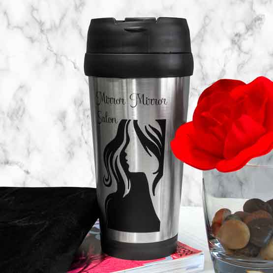 Custom Silver Travel Mug With Lid And Laser Engraved With Mirror Mirror Salon Logo On Shelf With Decor And Book