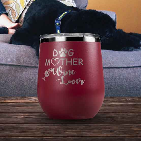 Maroon 12 Ounce Stemless Wine Tumbler Laser Engraved With Dog Mother Wine Lover Message On Coffee Table Near Couch With Dog