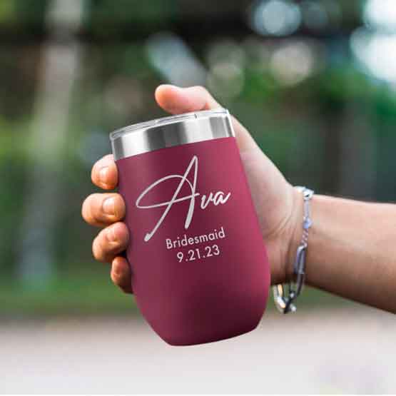 Woman Hand Outdoors Holding Custom Maroon Stemless Wine Tumbler Engraved With Name And Date And Bridesmaid Text