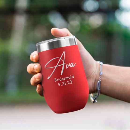 Woman Hand Outdoors Holding Custom Red Stemless Wine Tumbler Engraved With Name And Date And Bridesmaid Text