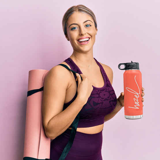 Woman In Workout Clothes Carrying Yoga Mat And Coral Thirty Two Ounce Water Bottle With Straw And Engraved Name
