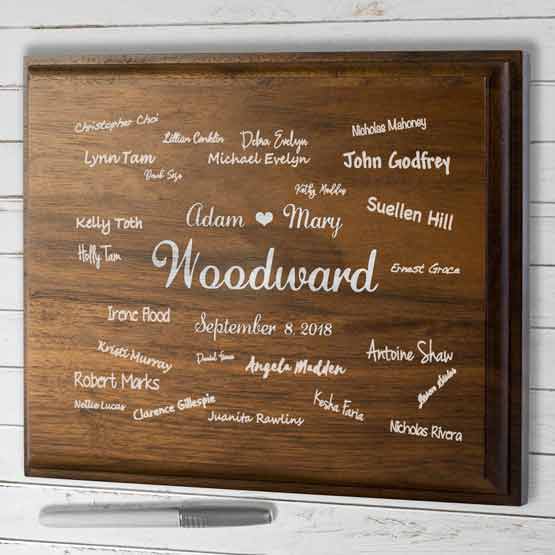 Custom Walnut Guest Book Plaque Featuring Couple Names And Guest Names And Date On A White Table With Marker