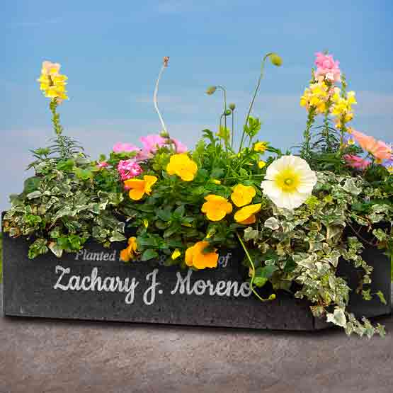 Granite Flower Planter On Shelf And Filled With Flowers And Engraved With Custom Name And Memorial Message