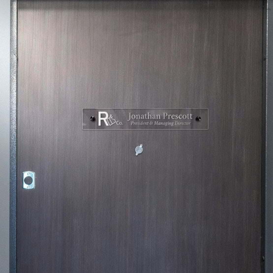 Clear Acrylic Office Name Plate Printed With Logo And Business President Details Mounted On Office Wall Via Black Standoffs