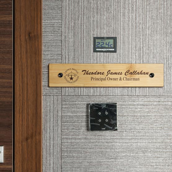 Custom Bamboo Office Name Plate Engraved With Chairman Details Mounted On Office Wall Via Black Standoffs Under Thermostat