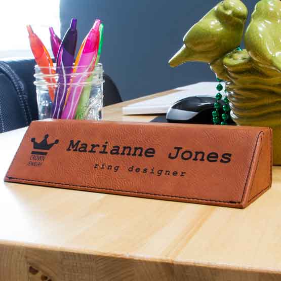 Rawhide Faux Leather Desk Wedge Engraved With Custom Logo And Employee Details On Wood Desk With Jar Of Pens