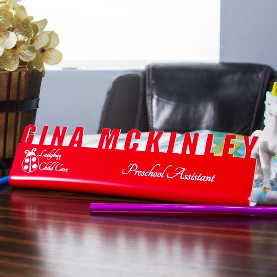 Custom Cutout Desk Name Plates On Desk Near Potted Plant.