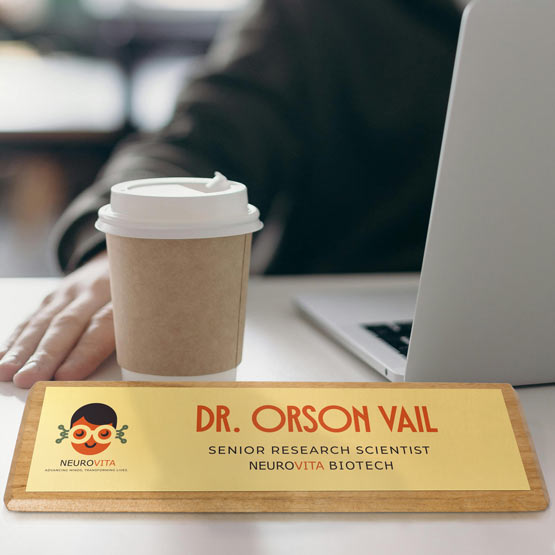 Man At Office Desk With Coffee And Red Alder Desk Wedge With Gold Aluminum Plate Printed With Tech Logo And Employee Details