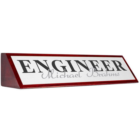 Rosewood Desk Wedge With White Aluminum Plate Printed With Engineer Michael Brahms In Black And Gray Against White Background