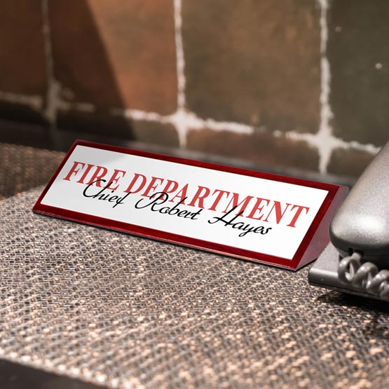 A custom 'Fire department' nameplate on a textured surface with a blurred background