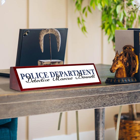 Desk nameplate with 'Police Department' and 'Detective Marcus Bennett' on a wooden surface.