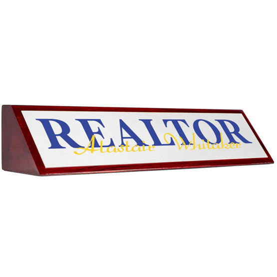 Rosewood Desk Wedge With Aluminum Plate Printed With Realtor Alastair Whitaker In Blue And Yellow Against A White Background