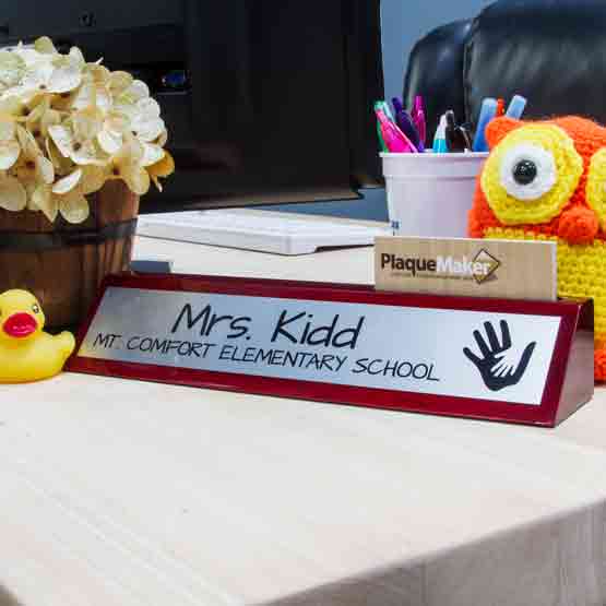 Rosewood Desk Wedge With Card Slot And Silver Aluminum Plate Printed With Teacher Details On Busy Work Desk With Monitor