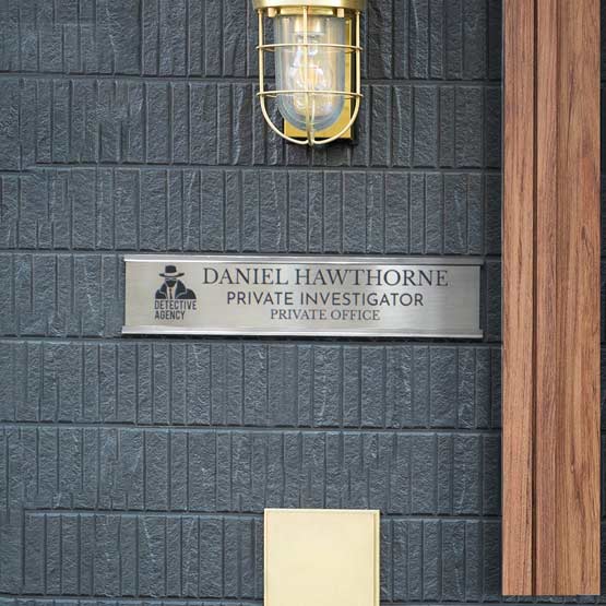 Stainless Steel Office Plate With Silver Mounting Bracket And Laser Fused With Logo And Office Details On Wall Below Sconce