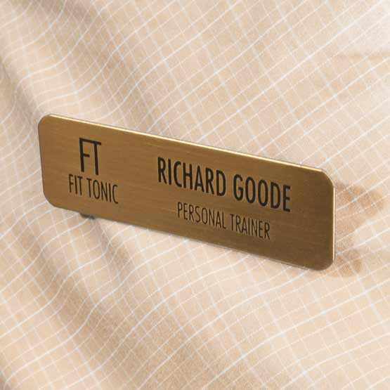 Custom Bronze Magnetic Name Badge Laser Fused With Logo And Name And Personal Trainer Text Fastened To A Plaid Shirt