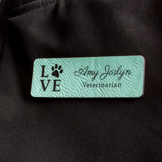 Laser Engraved Teal Custom Faux Leather Name Tag On Black Jacket.