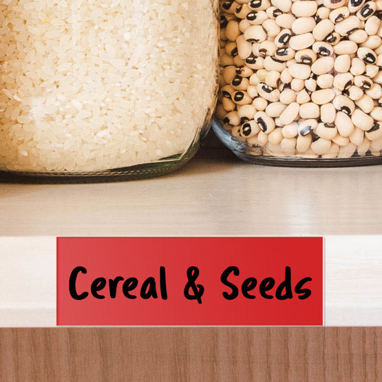 Plastic Red Name Tag Marked With Handwritten Cereal & Seeds Text In Black On A Shelf With Glass Jars