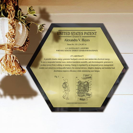 Honeycomb Patent Plaque With Black Acrylic Board And Gold Plate Printed With Sample Details Mounted Onto Wall Near Plant